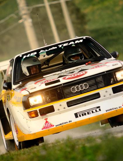 Audi rally car in action on a dirt road.