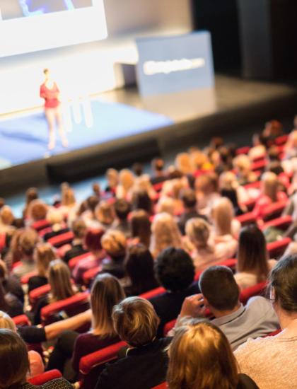 Conference with attentive audience in an auditorium.