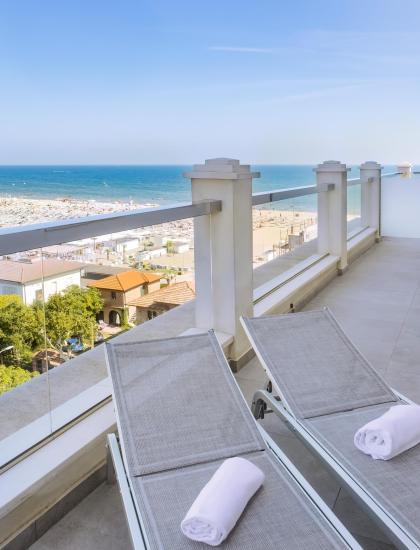 Terrazza con vista mare e lettini, perfetta per rilassarsi.