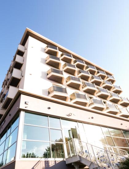 Modern building with unique balconies and blue sky.