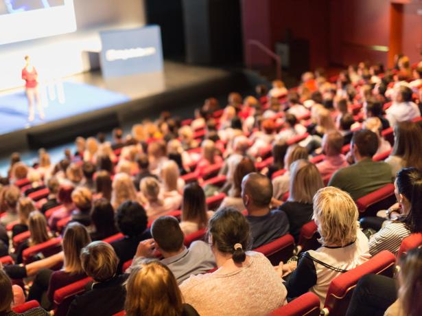 Conference with attentive audience in an auditorium.